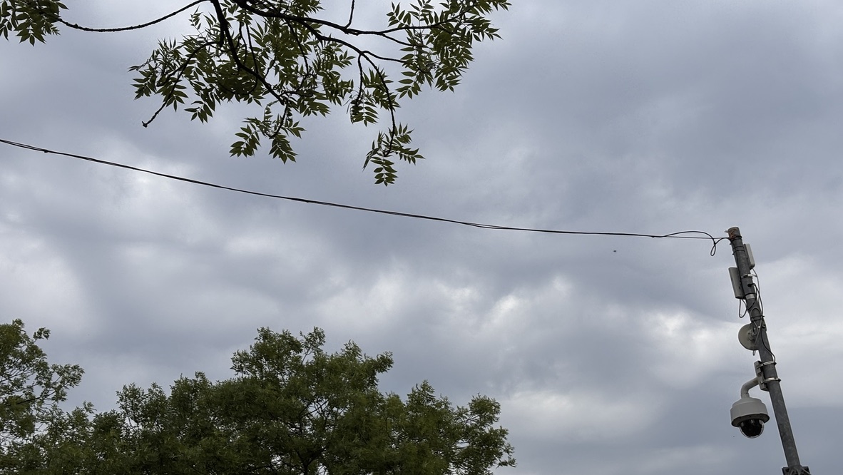 Bewakingscamera aan de rand van een bewolkte lucht