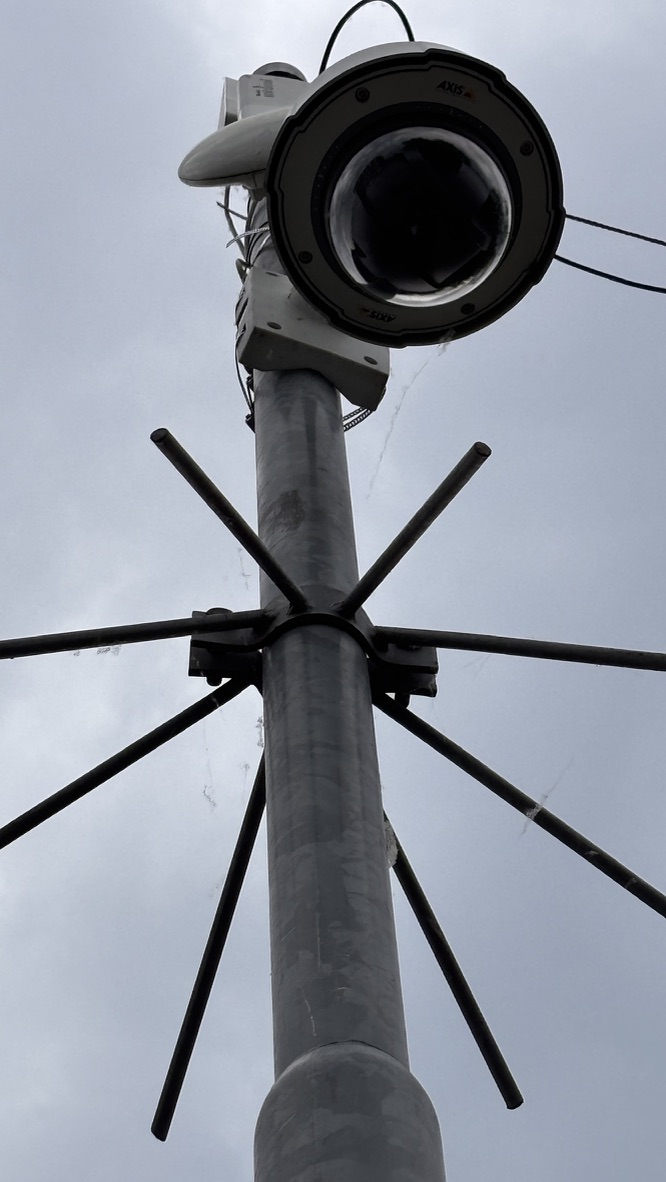 Bewakingscamera en metalen mast vanuit kikkerperspectief